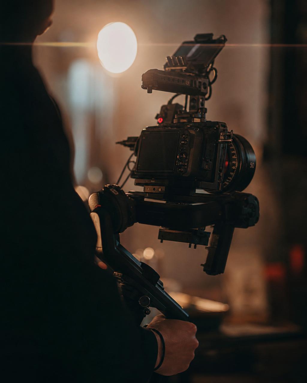 Filmkamera och rigg i produktion, varmt bakljus och cinematisk stämning